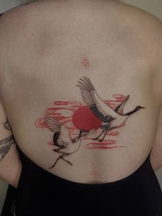 the back of a woman's body with two birds on it and red circles