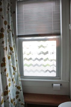 a bathroom with a toilet, window and shower curtain