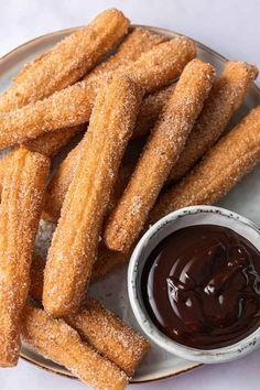 a plate with churros and dipping sauce on it