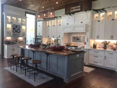 a large kitchen with white cabinets and wooden floors