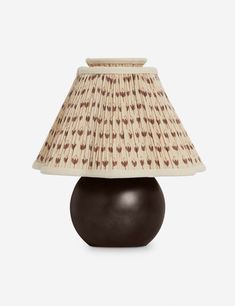 a lamp that is sitting on top of a wooden base with a shade over it