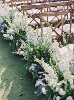 rows of chairs lined up with flowers and greenery