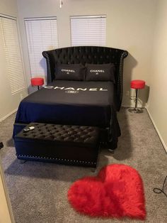 a bedroom with a black bed and red pillows