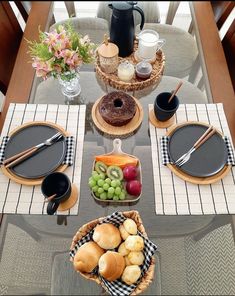 the table is set with plates, cups and bowls of food on it's placemats