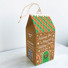 a small brown box with a gingerbread house on it's front and side