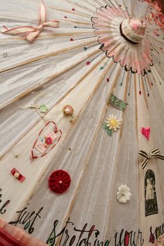 an umbrella that has been decorated with many different things on it, including flowers and ribbons