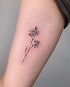 a small flower tattoo on the arm