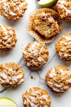 apple pie muffins with icing and apples on the side, next to an apple