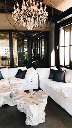 a white couch sitting in front of a window next to a table with black and white pillows