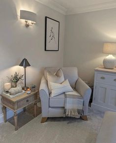 a living room with a couch, chair and two lamps on either side of the wall