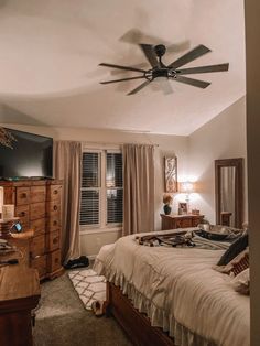 a bed room with a neatly made bed and a ceiling fan