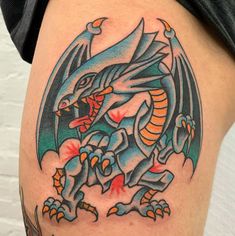 a close up of a tattoo with a dragon on it's thigh and an eyeball in the center