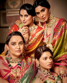 three women in colorful sari are posing for the camera