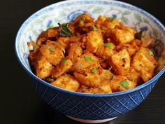 a blue and white bowl filled with tofu