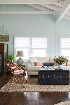 a living room filled with furniture and windows covered in shades of blue, white and red