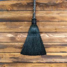 a broom is hanging on the side of a wooden wall