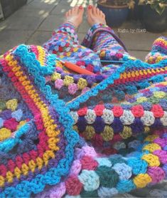 someone is laying down on the ground with their feet propped up and crocheted