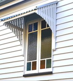 a white house with an open window and awning on the side of the house