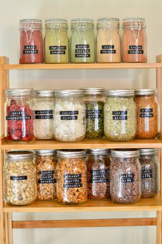 a wooden shelf filled with lots of different types of spices and condiments on top of it