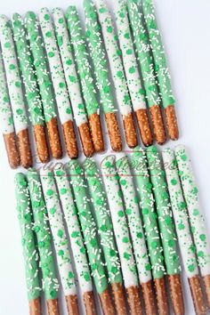 green and white decorated pretzels with sprinkles on them are arranged in rows