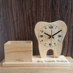 a tooth shaped clock next to a wooden block