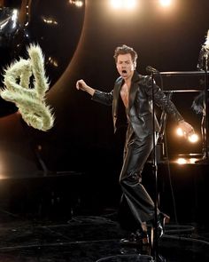 a man in a suit and feathered headpiece on stage