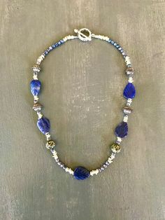 Carved Lapis Lazuli Leaves with Indonesian silver heishi beads and tribal beads with small sodalite spacers Silvertone toggle clasp  length measured clasp to clasp 18" All materials were found, cleaned and recycled by me. Silver Jewelry With Faceted Beads Made Of Lapis Lazuli, Silver Jewelry With Faceted Beads In Lapis Lazuli, Silver Beaded Necklaces With Lapis Lazuli Natural Stones, Silver Beaded Necklace With Lapis Lazuli Natural Stones, Silver Lapis Lazuli Gemstone Beads Necklace, Silver Beaded Necklace With Natural Lapis Lazuli Stones, Heishi Beads, Toggle Clasp, Lapis Lazuli