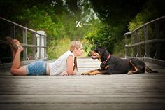 a woman laying on the ground next to a dog