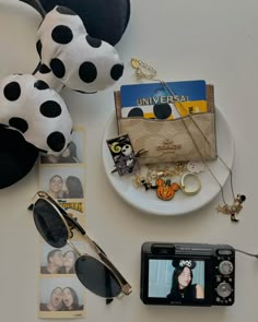 a white plate topped with photos and sunglasses next to a dalmatian stuffed animal