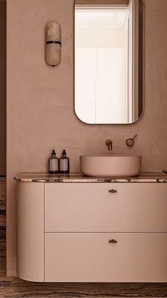 a bathroom with a sink, mirror and towel dispenser on the wall