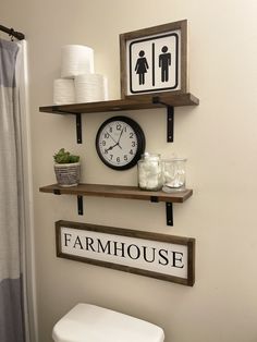 a bathroom with two shelves holding toilet paper and a clock on the wall above it