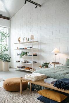 a bed room with a neatly made bed next to a window and a book shelf