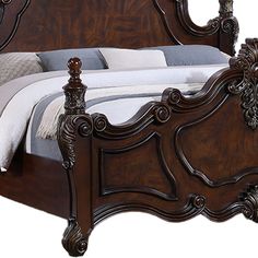 a wooden bed with an ornate headboard and foot board on it's side