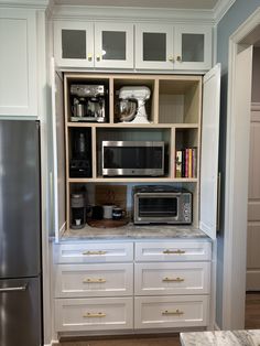 a kitchen with white cabinets and stainless steel appliances in the cupboards that are built into the wall