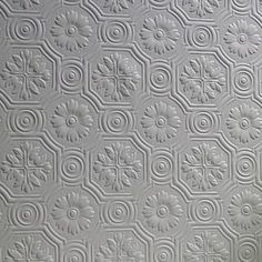 a close up view of a white ceiling tile with circles and flowers on the surface