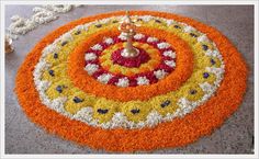 an orange and white flowered design on the floor with a candle in the center