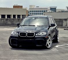 a black car is parked in an empty parking lot