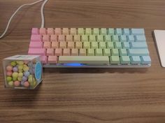 a computer keyboard and mouse on a wooden table with candy balls in front of it