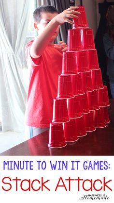 a young boy is playing with a stack of cups that are stacked on top of each other