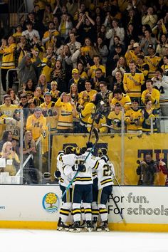 the hockey players are congratulating each other in front of an arena full of fans