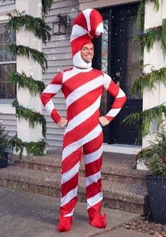 a man in a red and white striped costume standing on the sidewalk with his hands on his hips