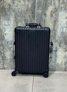 a black suitcase sitting on top of a cement floor