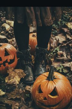 two pumpkins sitting on the ground in front of some legs and feet with black socks