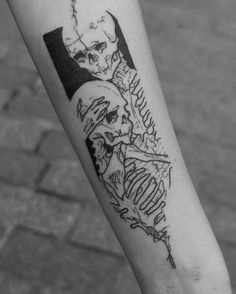 a black and white photo of a person's arm with a skeleton tattoo on it