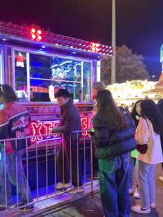 people standing in front of a food truck at night