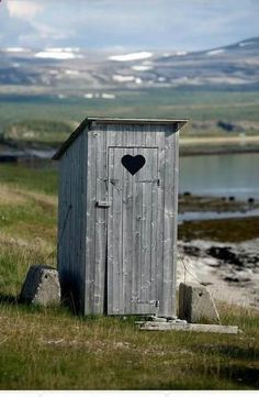 an outhouse with a heart on the door