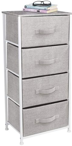 a white and grey dresser with three drawers on top of it, next to a pair of eyeglasses