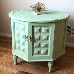 a small green cabinet sitting on top of a hard wood floor