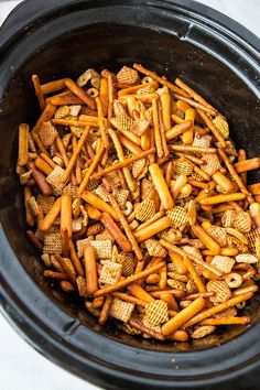 a crock pot filled with cheetos and crackers sitting on top of a table