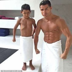 two young men standing next to each other in towels